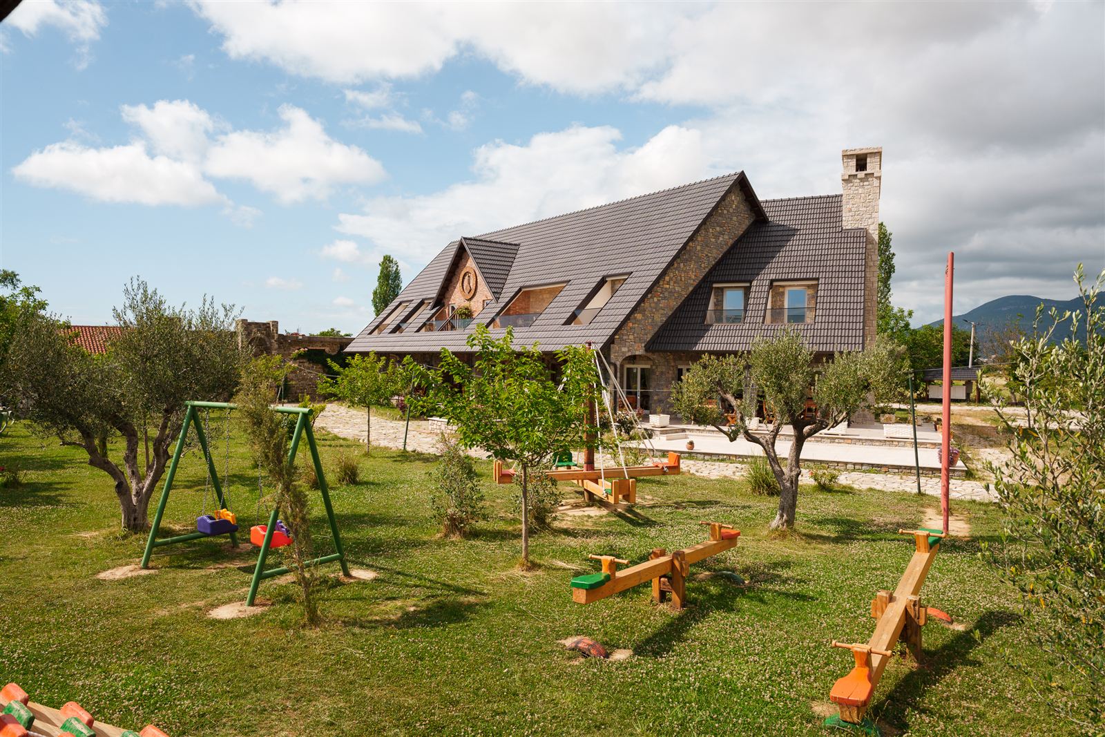 Handmade wooden playground with swings and see-saws among the olive trees